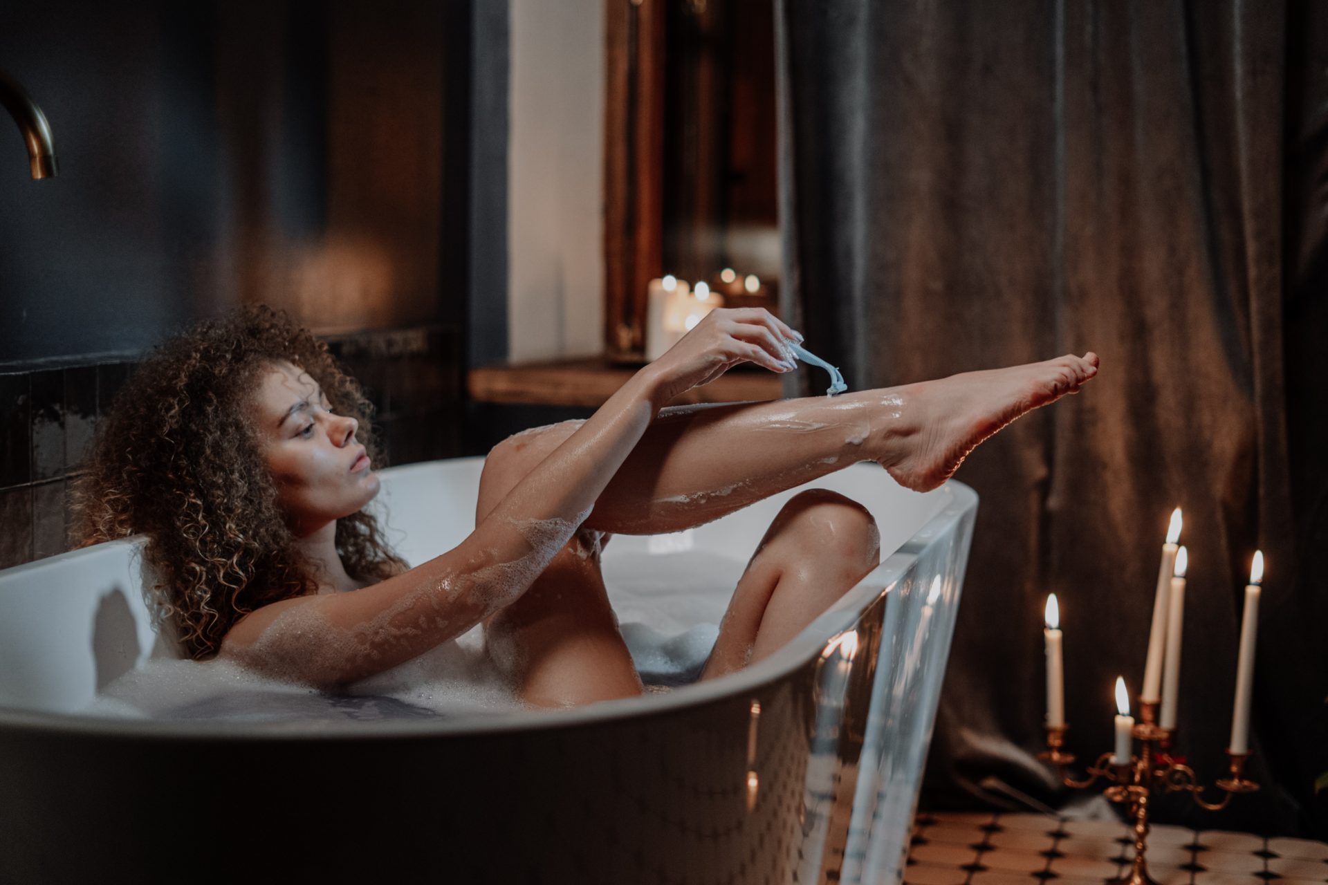 vegan razor subscription service woman shaving legs in the bath tub